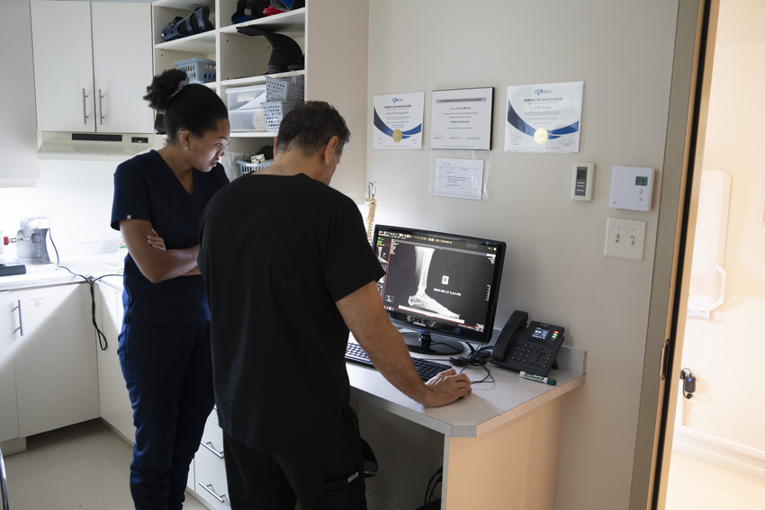 Two doctors discussing in front of a foot x-ray