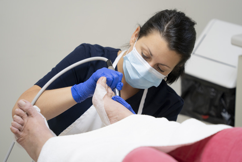 Infirmière qui administre un soin à un pied